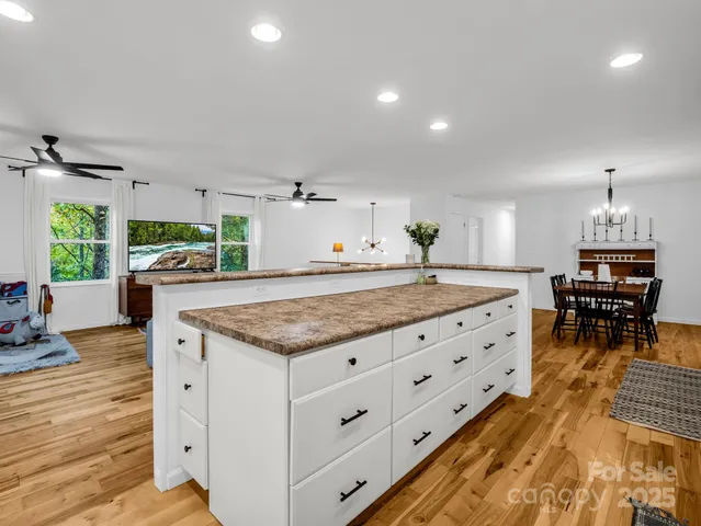 a kitchen with granite countertop a stove oven and a dining table