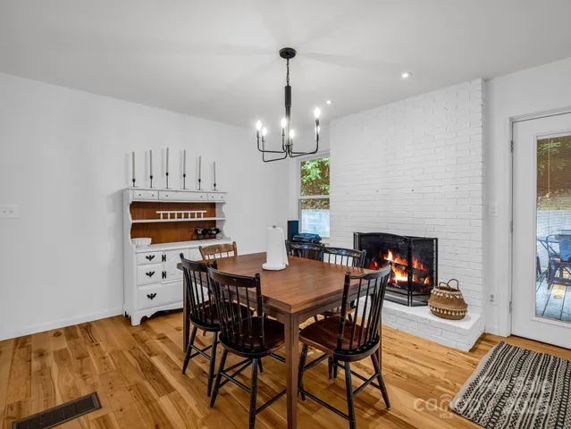 a view of a dining room with furniture a chandelier and wooden floor