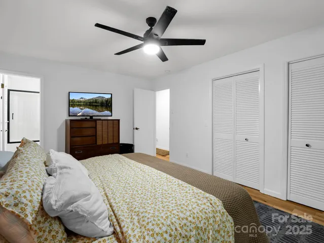 a bedroom with a large bed and a chandelier