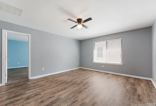 a view of empty room with wooden floor