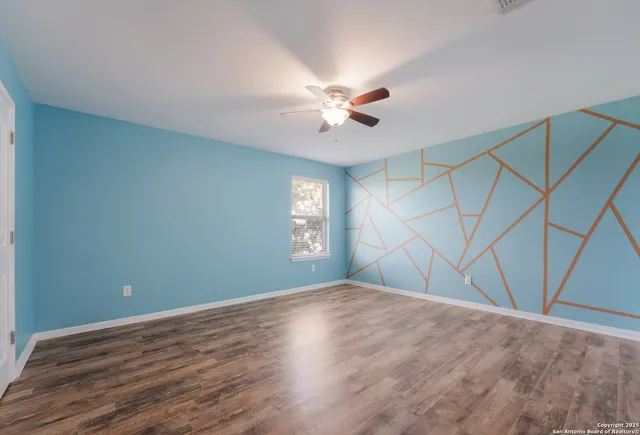 a view of an empty room with wooden floor