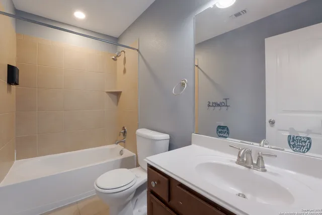 an empty room with wooden floor ceiling fan and windows
