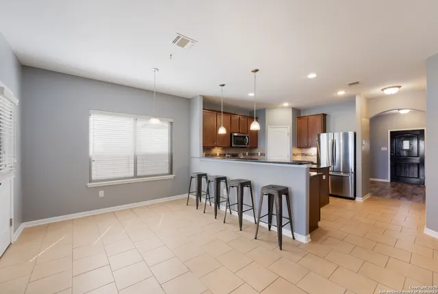 a open kitchen with white cabinets and stainless steel appliances