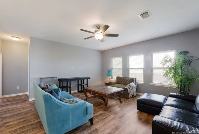 a living room with furniture and a wooden floor