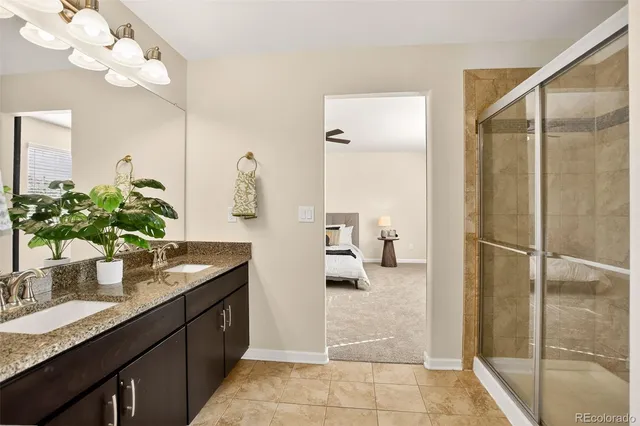 a bathroom with a granite countertop sink a mirror and a shower