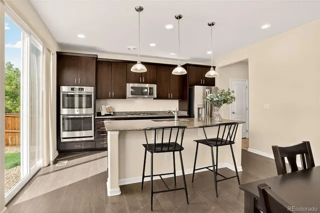 a kitchen with stainless steel appliances granite countertop a kitchen island a stove and a refrigerator