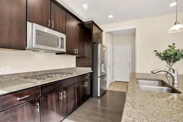a kitchen with stainless steel appliances granite countertop a sink stove and refrigerator