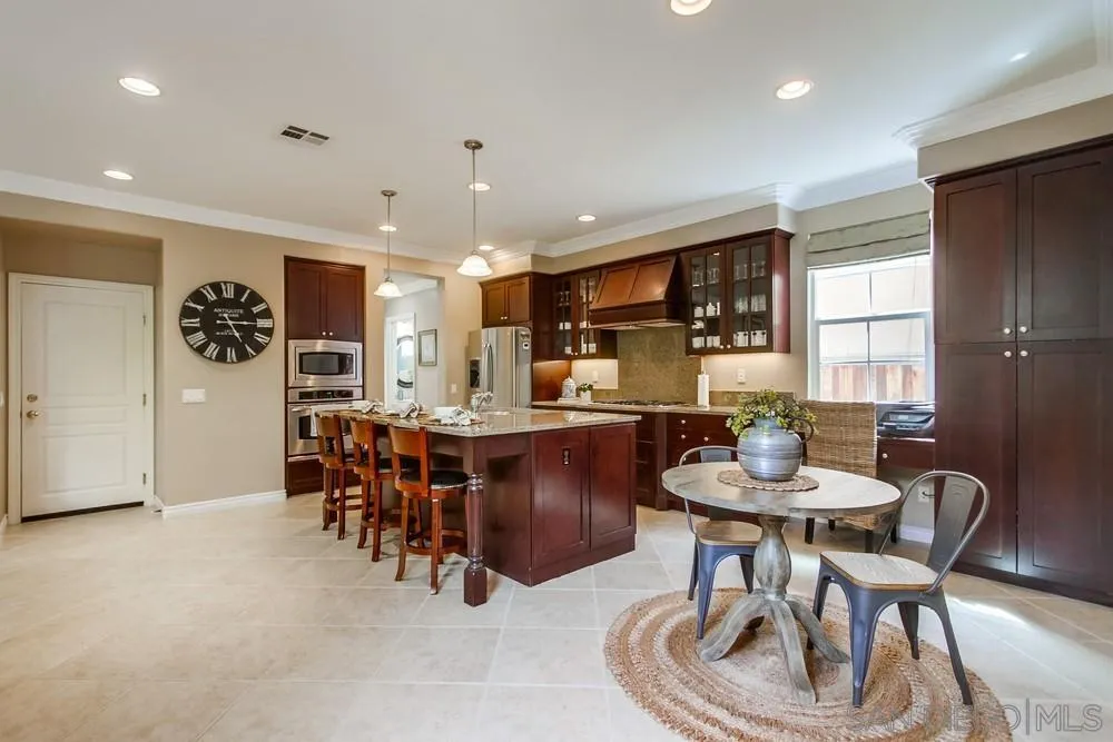 2665 Paradise Road Carlsbad, CA 92009 - Photo 9 of 52 a dining room with kitchen island furniture a chandelier and kitchen view
