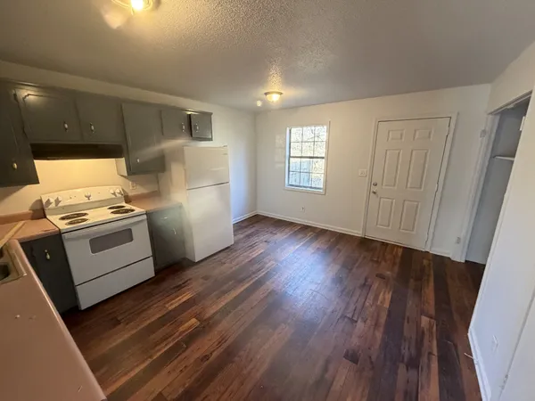 a kitchen with a refrigerator wooden floor and electronic appliances