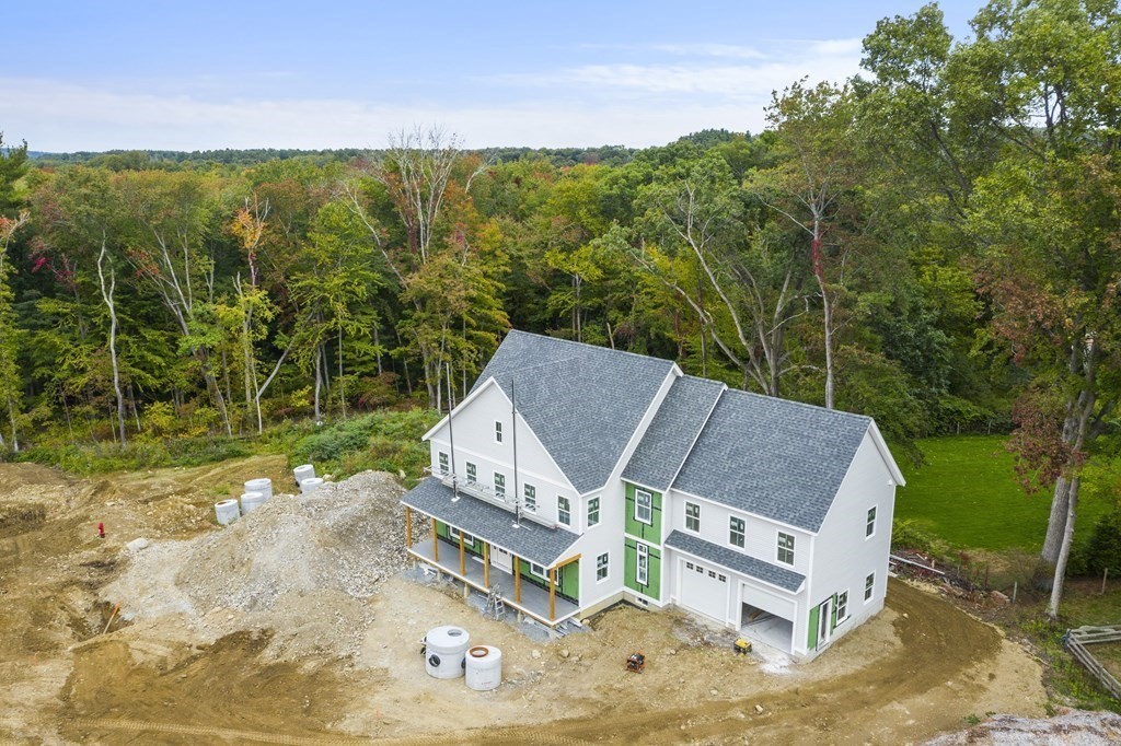 a view of a white house with a big yard and large trees