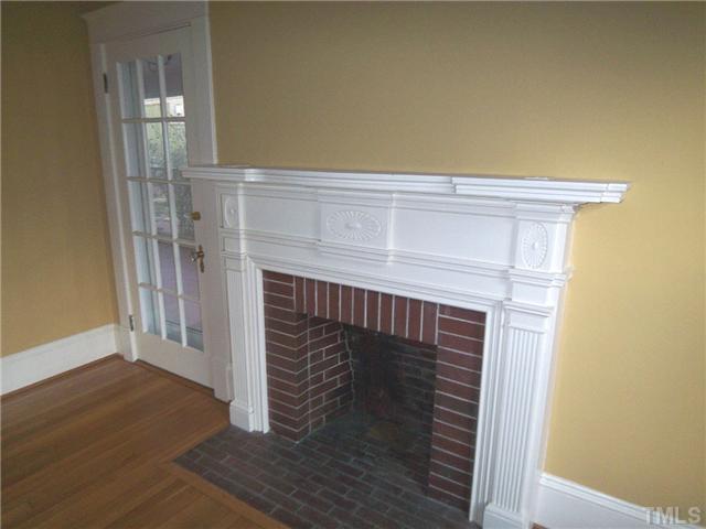 912 West Johnson Street Raleigh, NC 27605 - Photo 4 of 12 a close view of an empty room with wooden floor and a fireplace
