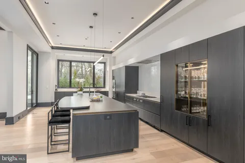 a kitchen with a sink a counter top space and living room view
