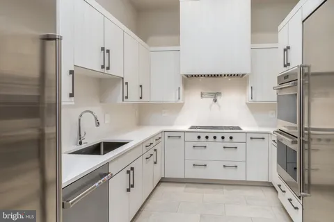 a kitchen with white cabinets and a sink