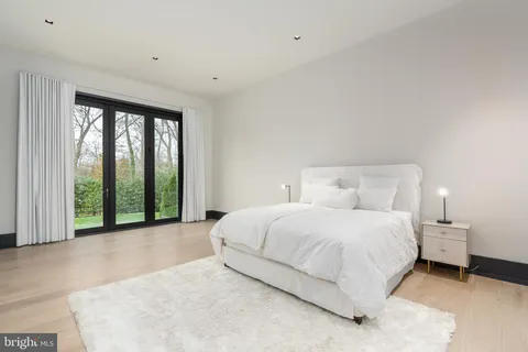 a spacious bedroom with a bed and a chandelier