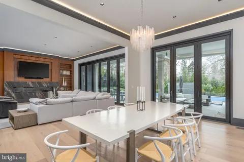 a large living room with stainless steel appliances granite countertop couches a fireplace and a large window with wooden floor