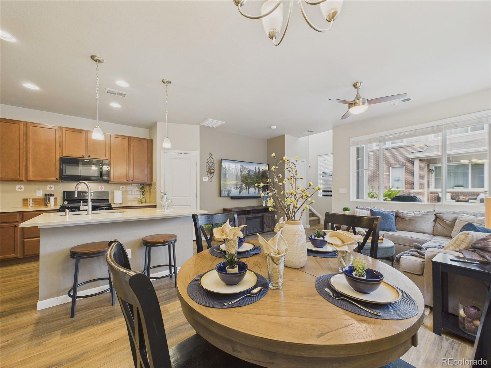 15516 West 64th Loop, Unit F Arvada, CO 80007 - Photo 14 of 23 a kitchen with stainless steel appliances granite countertop a dining table and chairs with wooden floor