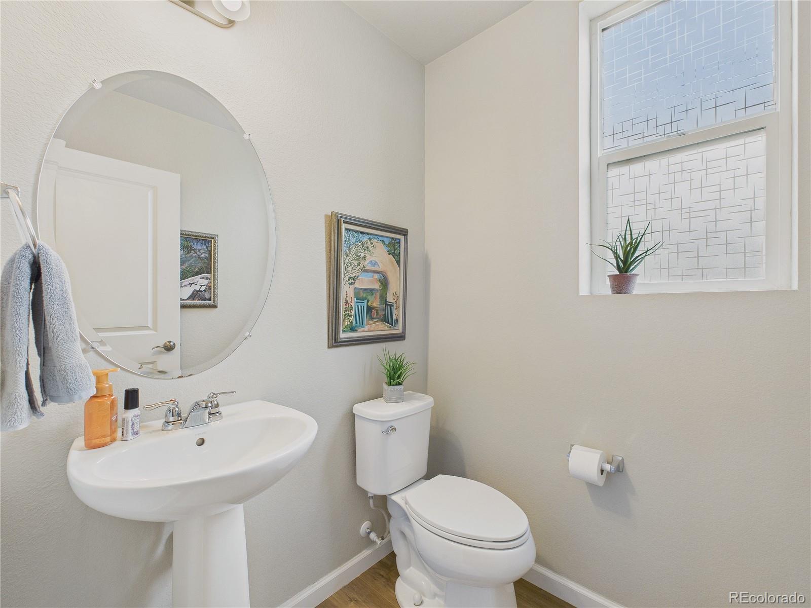 15516 West 64th Loop, Unit F Arvada, CO 80007 - Photo 17 of 23 a bathroom with a sink a mirror and a toilet