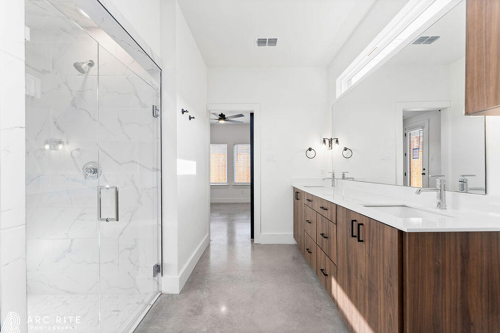 4509 22nd Place Lubbock, TX 79407 - Photo 13 of 32 a spacious bathroom with double vanity and a mirror