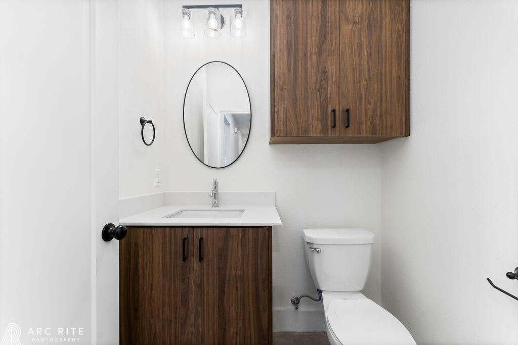 4509 22nd Place Lubbock, TX 79407 - Photo 28 of 32 a bathroom with a toilet a sink and a mirror