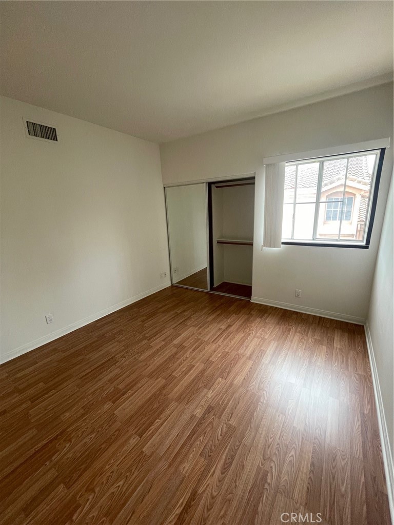10010 Reseda Boulevard, Unit D Northridge, CA 91324 - Photo 13 of 22 an empty room with wooden floor and windows