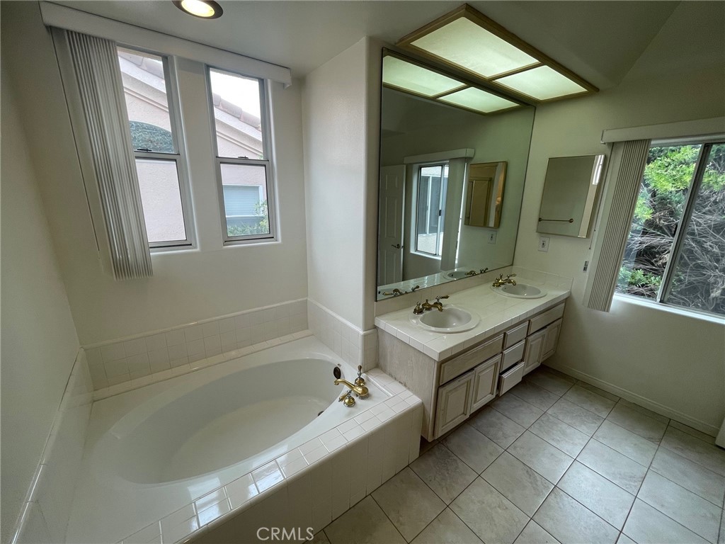 10010 Reseda Boulevard, Unit D Northridge, CA 91324 - Photo 18 of 22 a bathroom with a tub sink and mirror