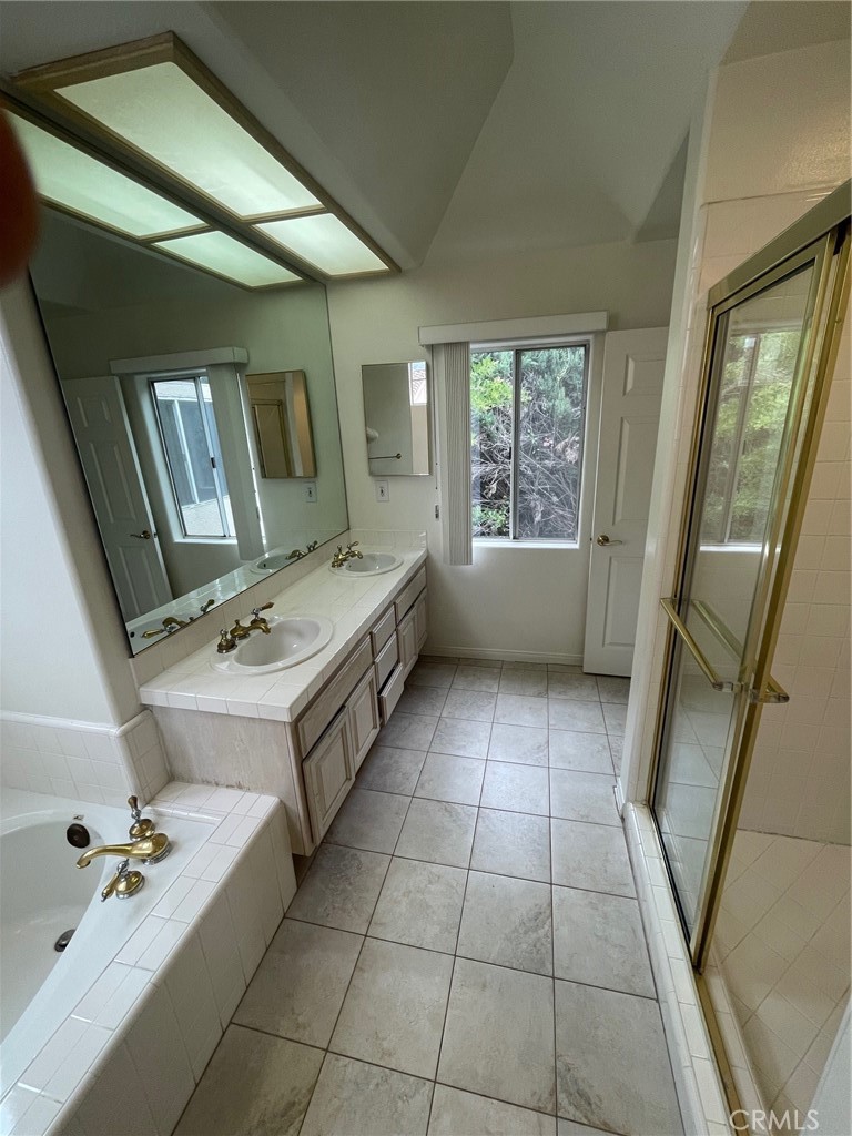 10010 Reseda Boulevard, Unit D Northridge, CA 91324 - Photo 19 of 22 a bathroom with a tub sink and mirror