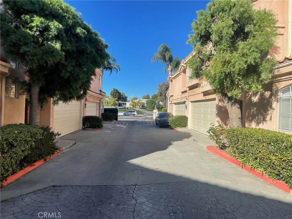 10010 Reseda Boulevard, Unit D Northridge, CA 91324 - Photo 22 of 22 a view of a white house with a yard and potted plants