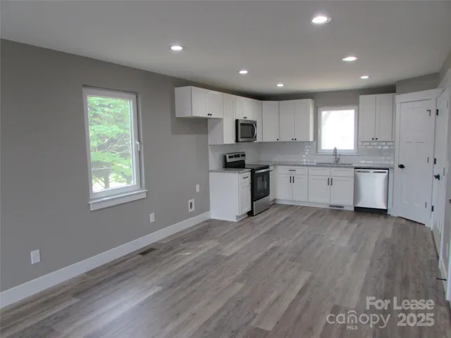 a large kitchen with stainless steel appliances granite countertop a stove a sink and a refrigerator