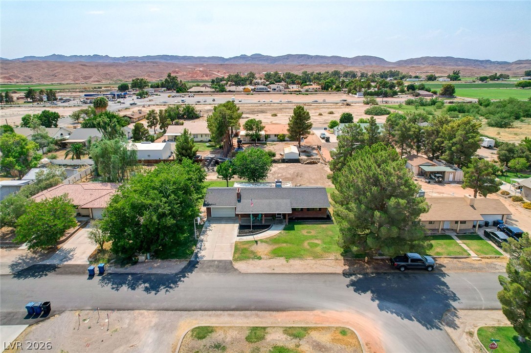 3765 Berkeley Street Logandale, NV 89021 - Photo 85 of 87 An aerial perspective reveals a charming residence nestled amidst a vibrant green landscape with mountain views.