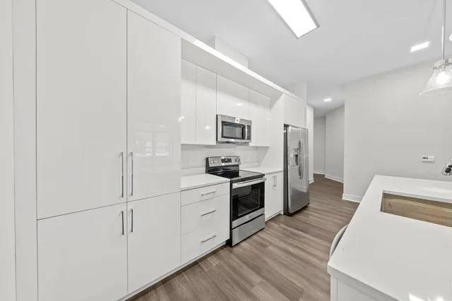 a kitchen with white cabinets and stainless steel appliances