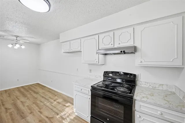 a kitchen with white cabinets and a stove