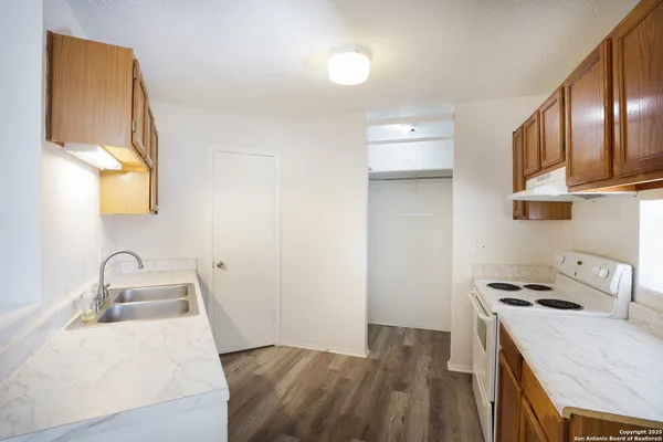 a kitchen with a sink a stove and cabinets