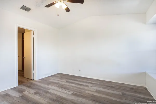 a view of empty room with wooden floor