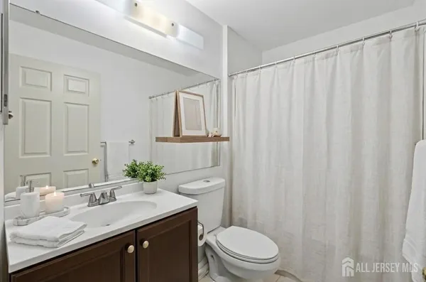 a bathroom with a sink a toilet and shower curtain