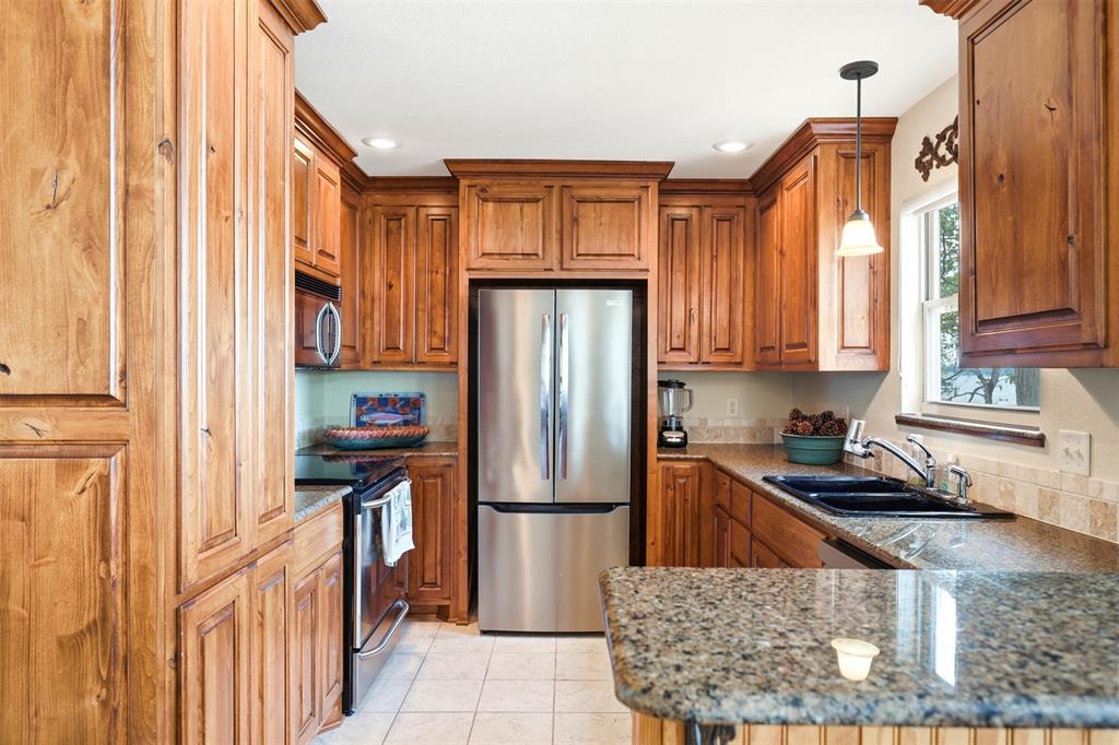 307 South Park Road Scroggins, TX 75480 - Photo 13 of 33 a kitchen with stainless steel appliances granite countertop a refrigerator a stove and a sink with wooden cabinets