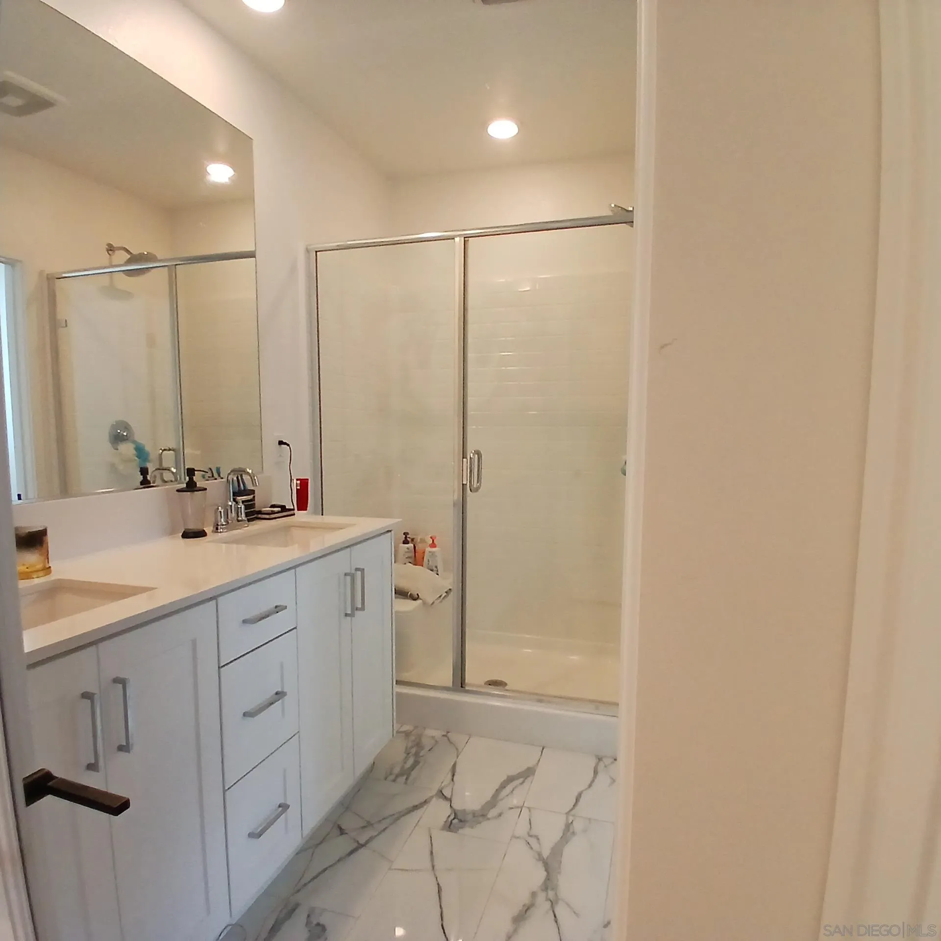 2430 Cascalote Loop San Diego, CA 92154 - Photo 4 of 19 a spacious bathroom with a shower sink and mirror
