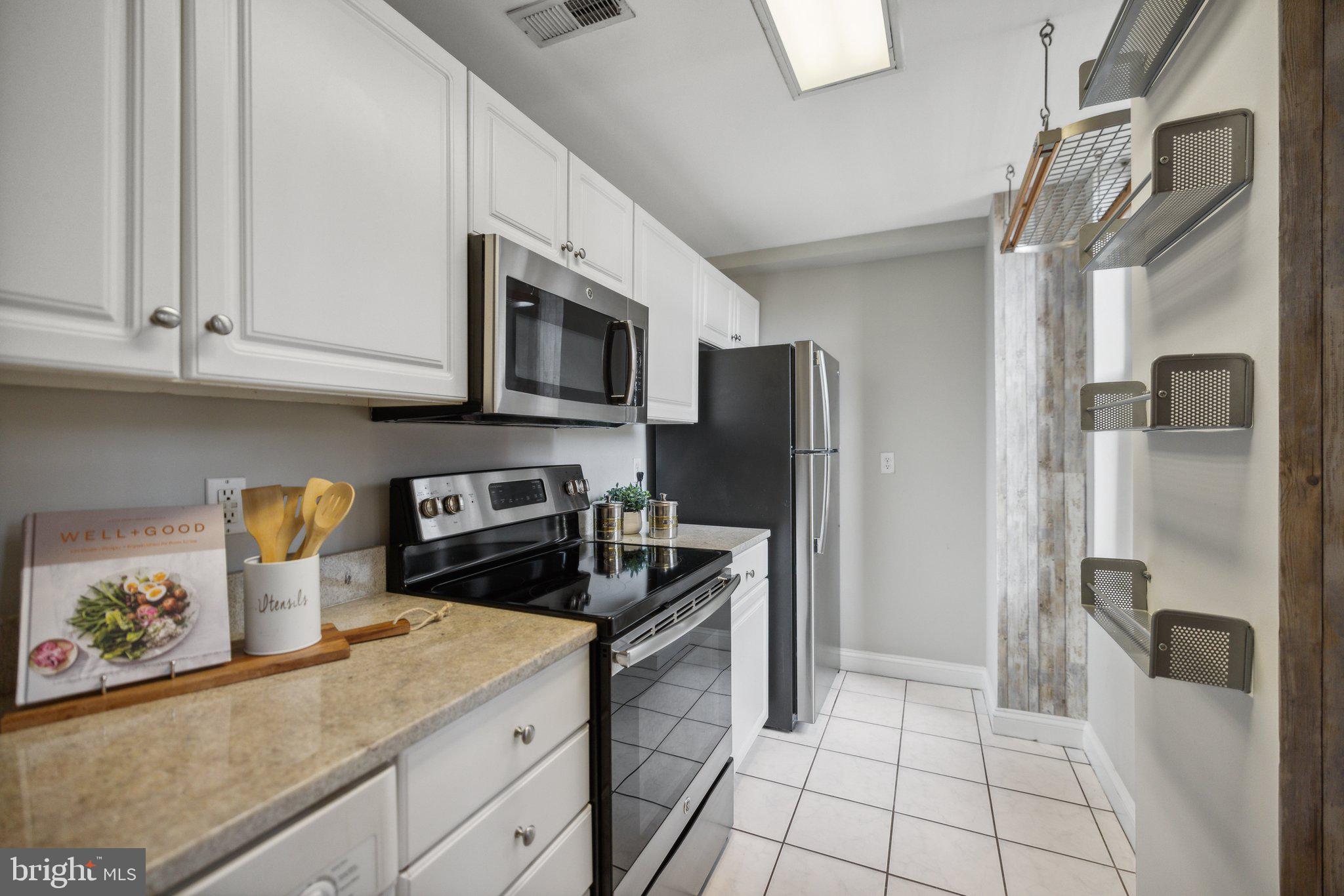 1621 T Street Northwest, Unit 307 Washington, DC 20009 - Photo 7 of 15 a kitchen with stainless steel appliances granite countertop a refrigerator a stove a sink dishwasher and a refrigerator with wooden cabinets