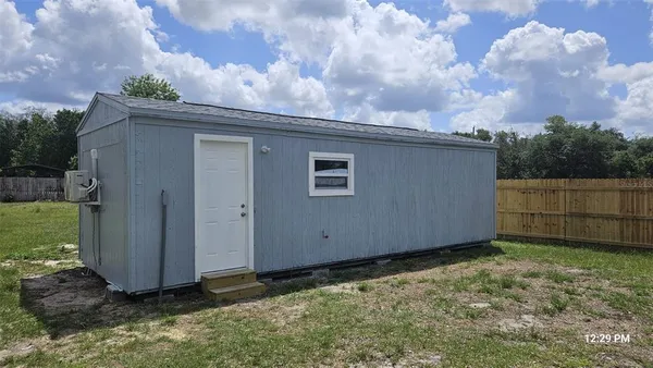 a backyard of a house with lots of green space and wooden fence