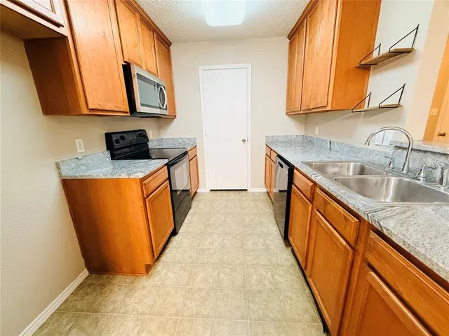 a kitchen with stainless steel appliances granite countertop a stove a sink and a microwave