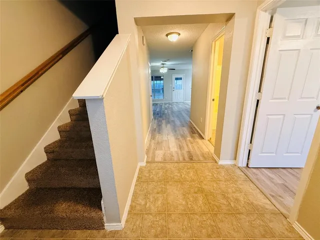 a view of a hallway with wooden floor and staircase
