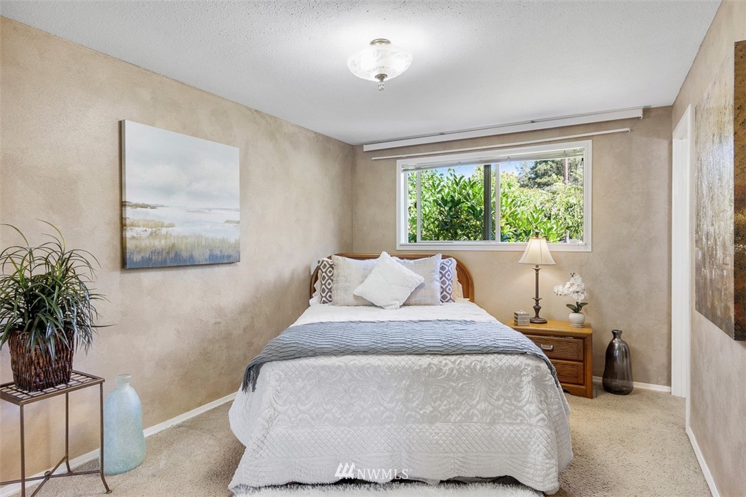 507 South 38th Court Renton, WA 98055 - Photo 15 of 40 a bedroom with a large bed and a potted plant