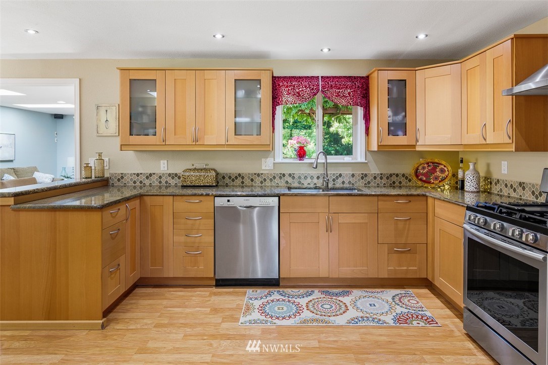 507 South 38th Court Renton, WA 98055 - Photo 6 of 40 a kitchen with granite countertop a sink stainless steel appliances and cabinets