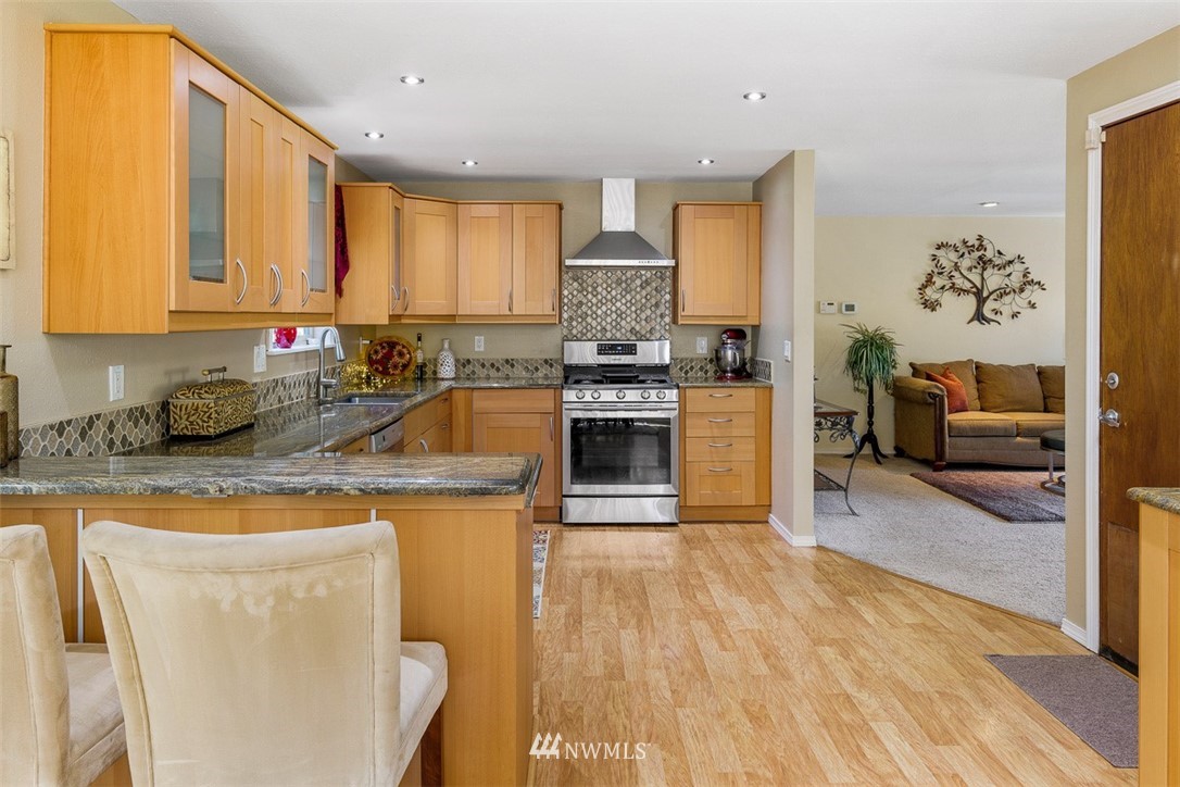 507 South 38th Court Renton, WA 98055 - Photo 7 of 40 a kitchen with stainless steel appliances granite countertop a refrigerator a stove top oven a sink and dishwasher