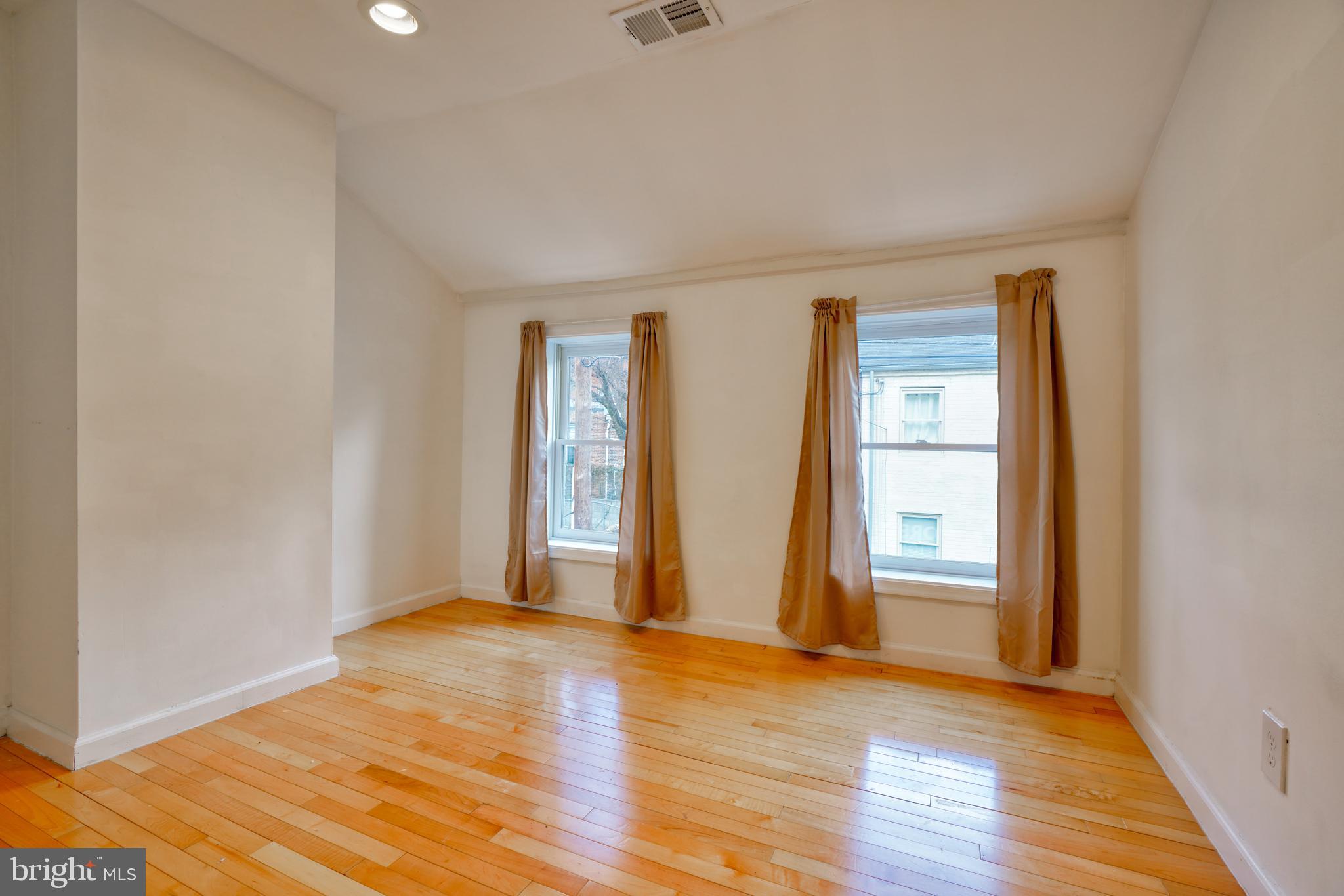 1029 Booth Street Baltimore, MD 21223 - Photo 12 of 21 an empty room with wooden floor and windows