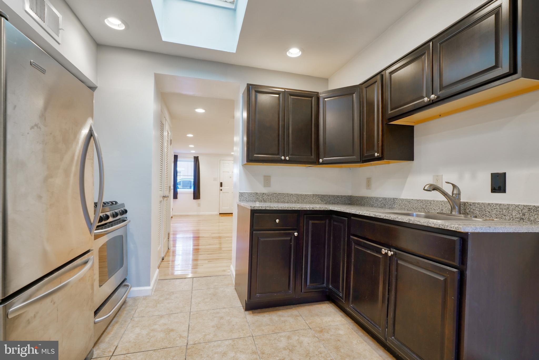 1029 Booth Street Baltimore, MD 21223 - Photo 21 of 21 a kitchen with stainless steel appliances granite countertop a refrigerator and a stove top oven