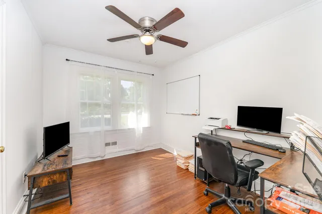 a view of a workspace with furniture and a window