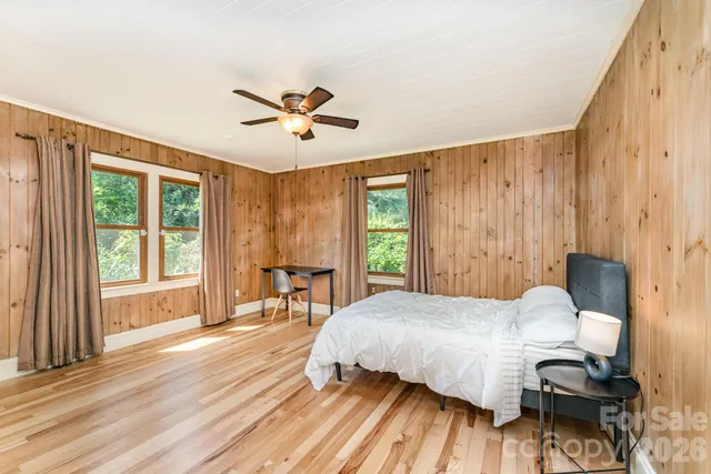 a bedroom with a bed and wooden floor