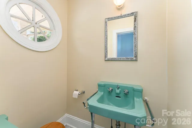 a bathroom with a small sink and a mirror