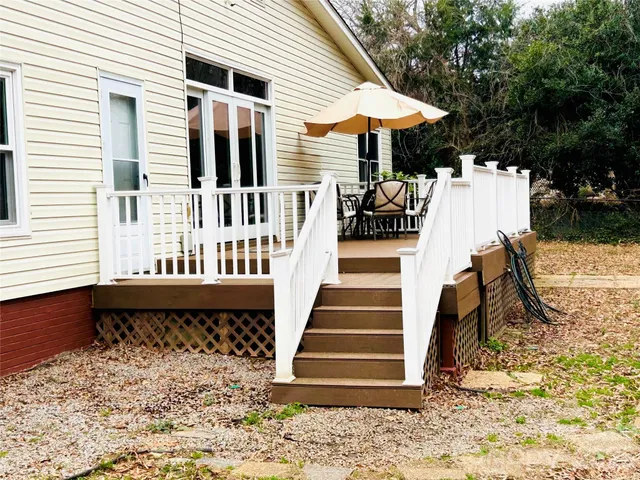 a view of a patio with table and chairs with wooden fence and floor