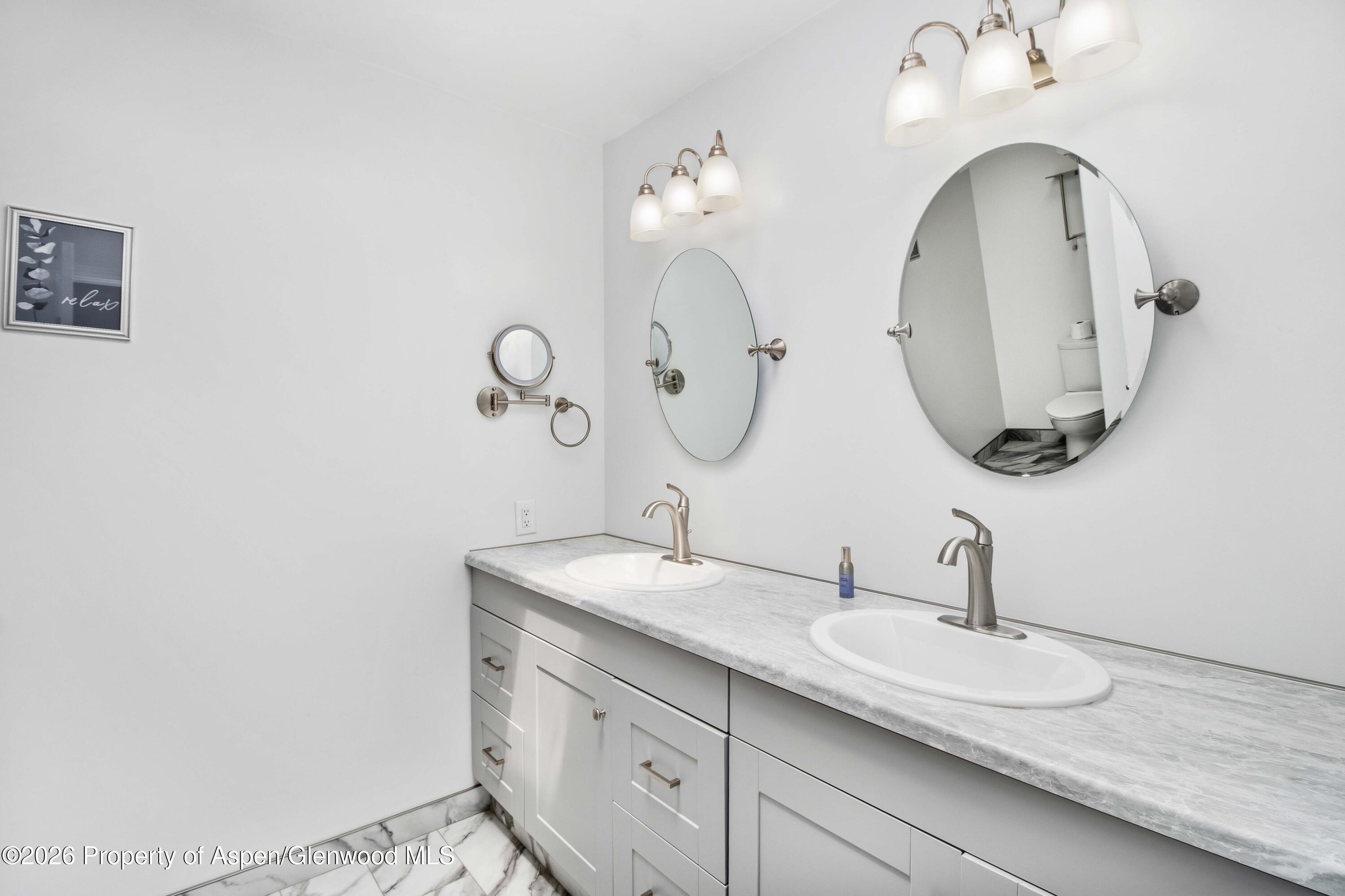 660 Aspen Avenue Rifle, CO 81650 - Photo 12 of 30 a bathroom with double vanity sinks and a mirror